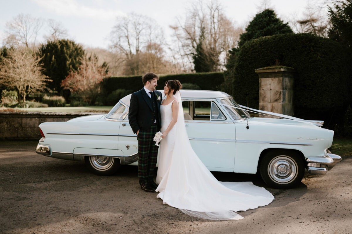 Newly married couple beside a vintage car at Balbirnie House