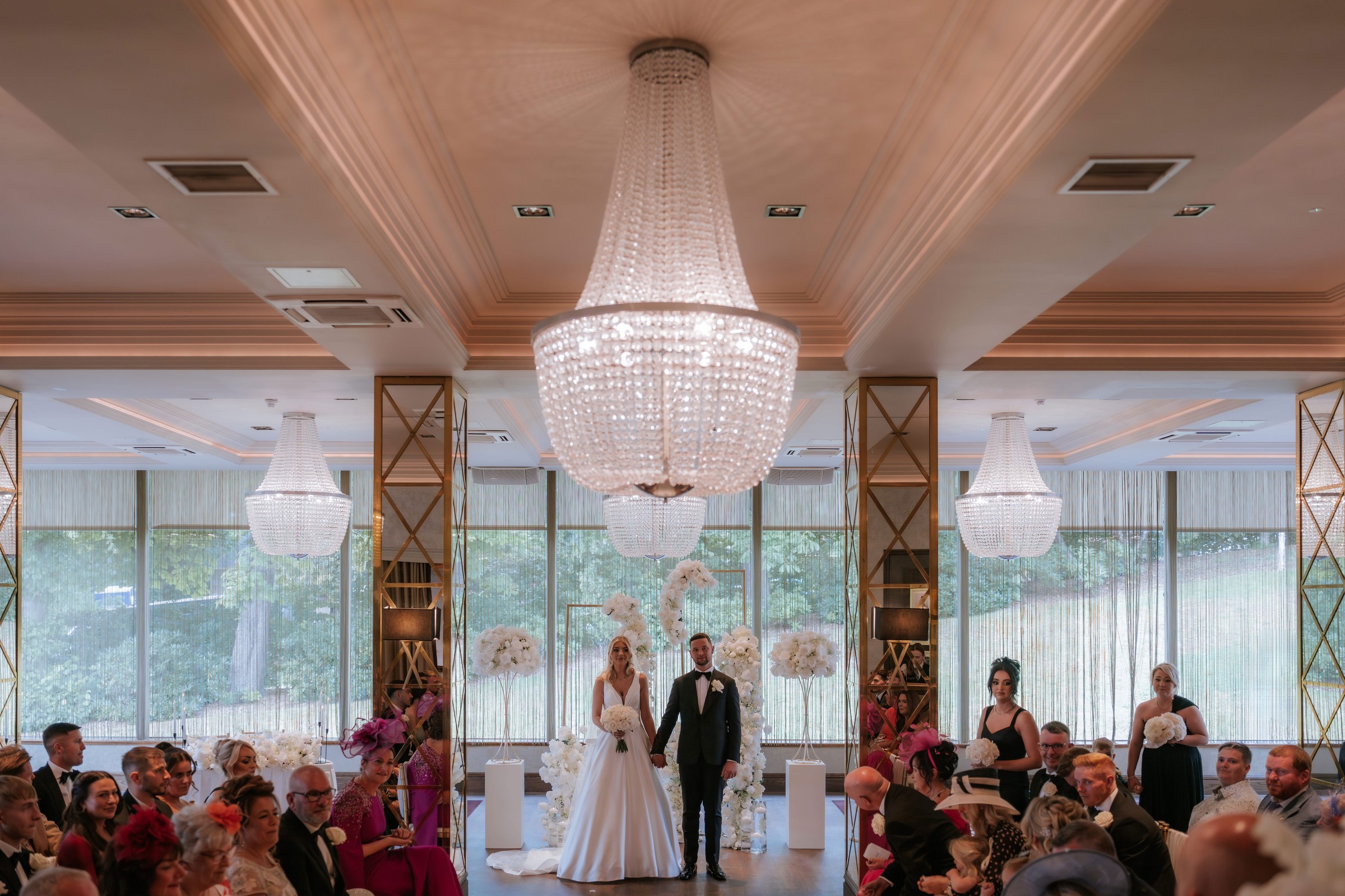 Grand Ballroom ceremony at Boclair House beneath crystal chandeliers