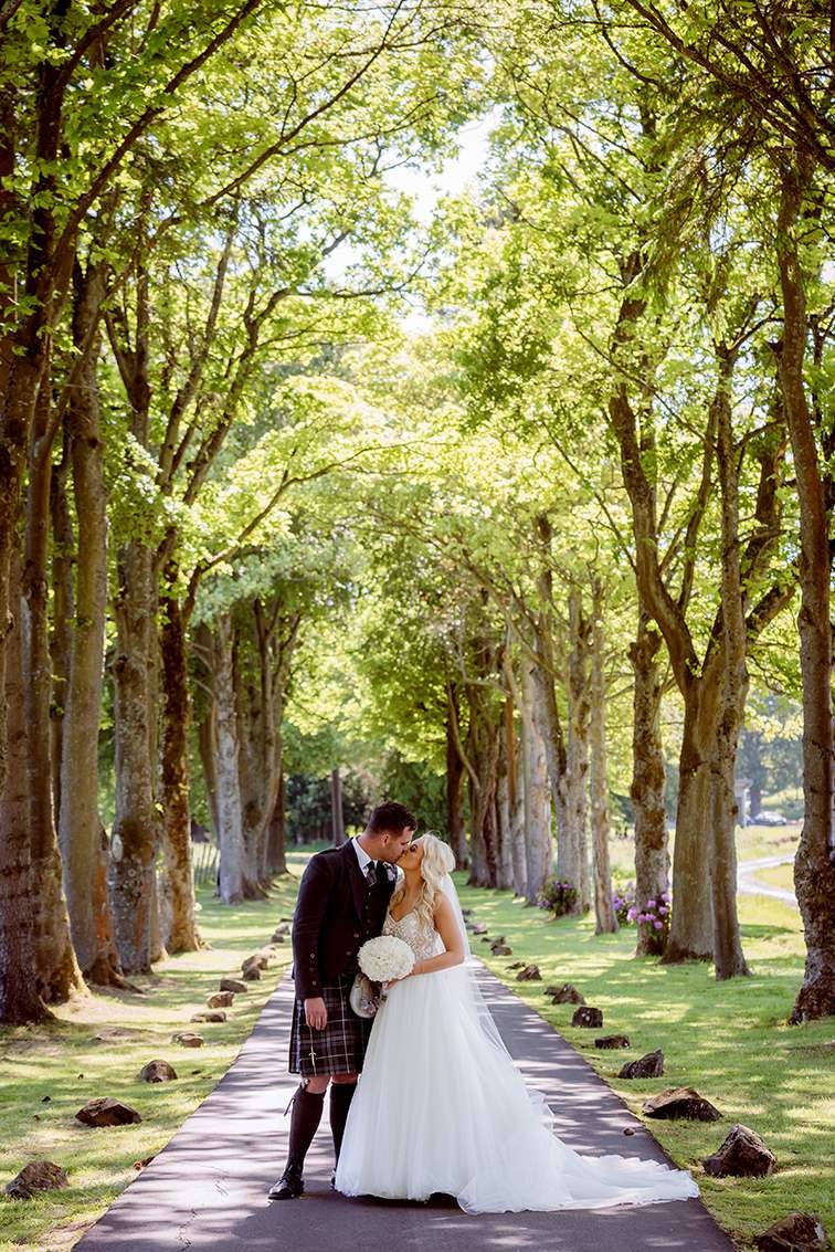 Newlyweds embracing on the Glenbervie drive.