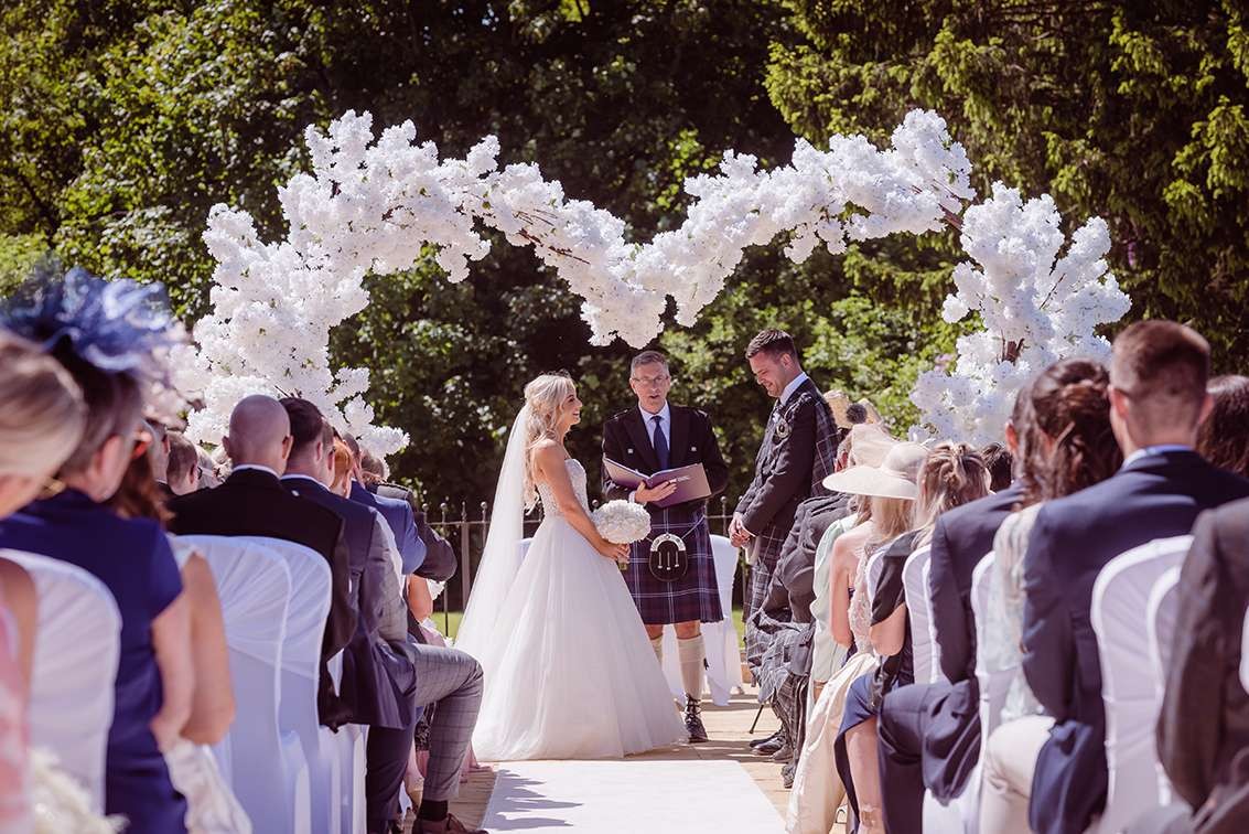 Couple exchanging vows at an outdoor Glenbervie ceremony.