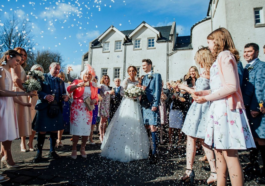 Newlyweds leaving Glenskirlie Castle through a confetti line.