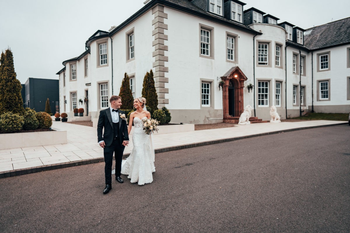 Newlyweds outside the white facade of Hetland Hall.