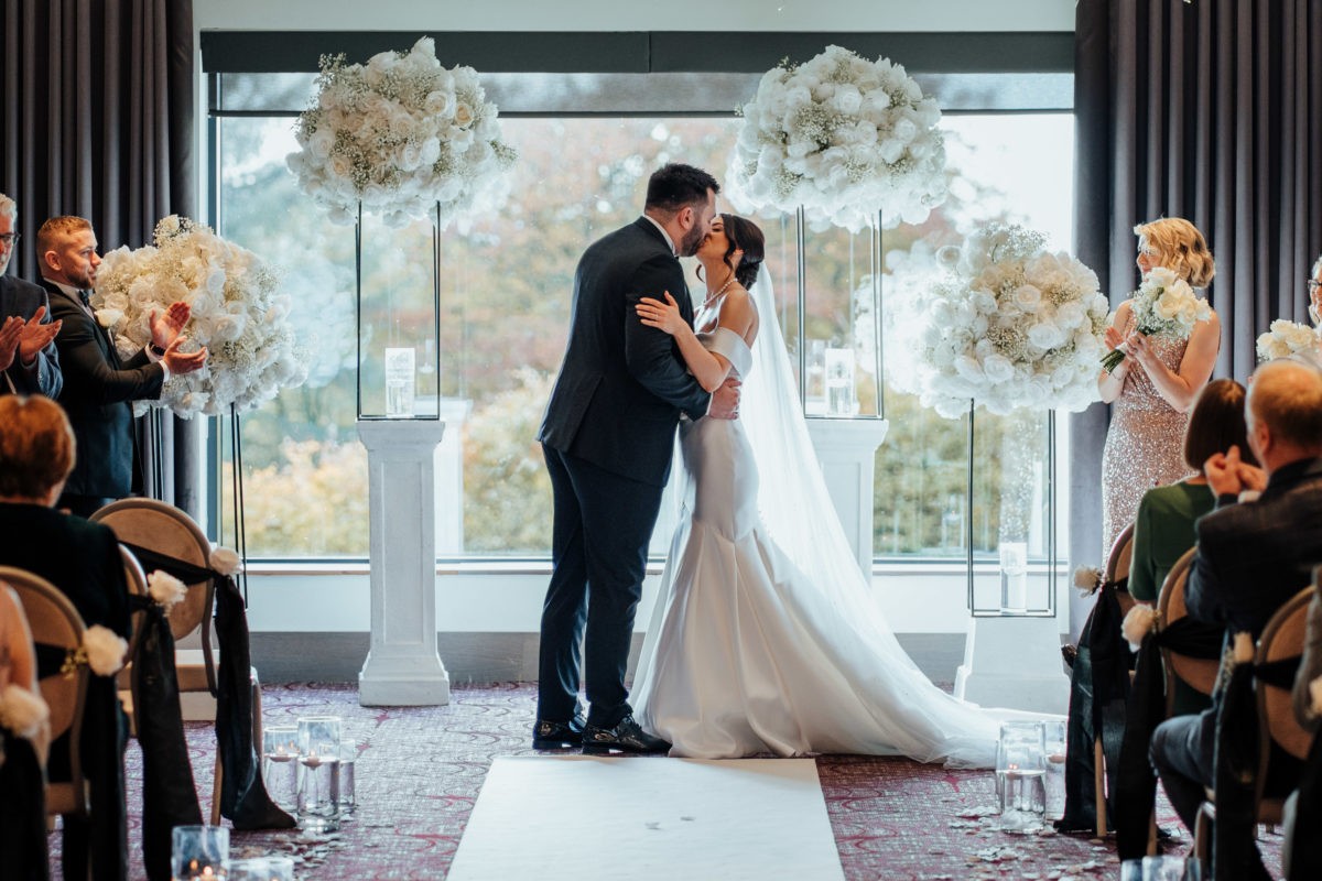 Couple kissing during an indoor ceremony at Hetland Hall.