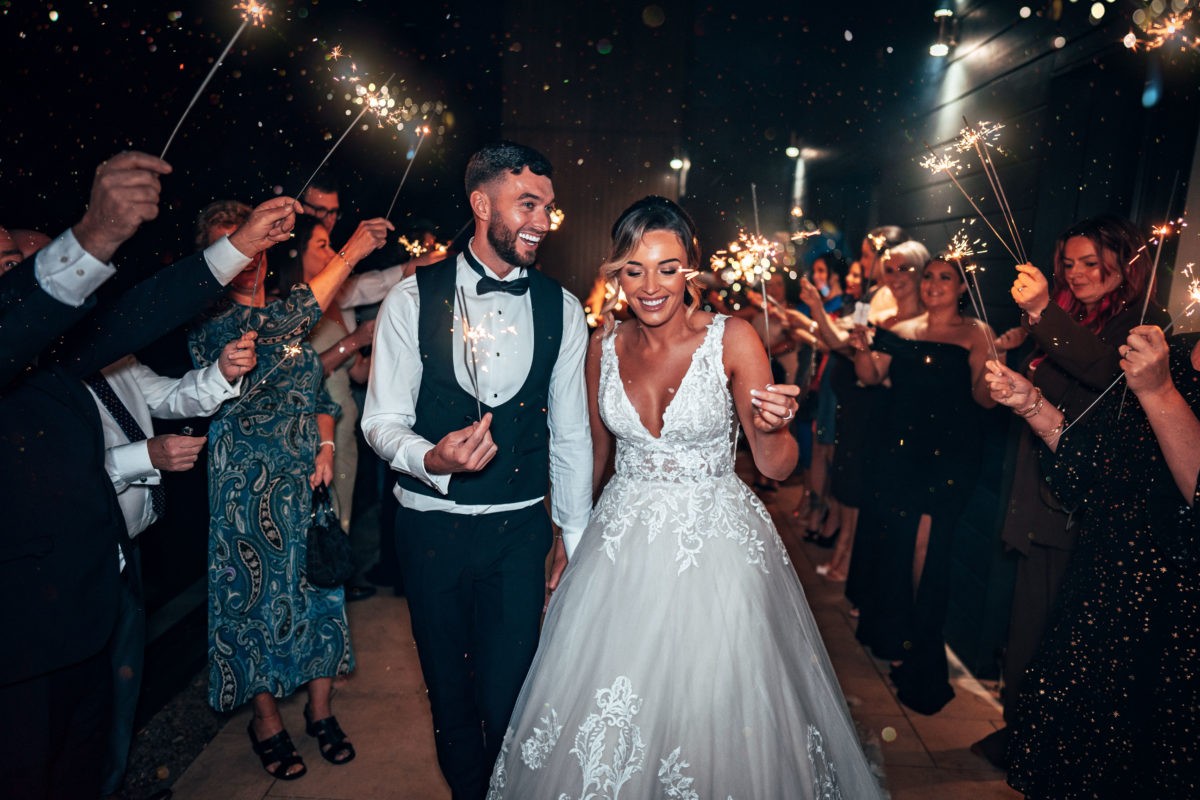 Newlyweds walking through sparklers at Hetland Hall.